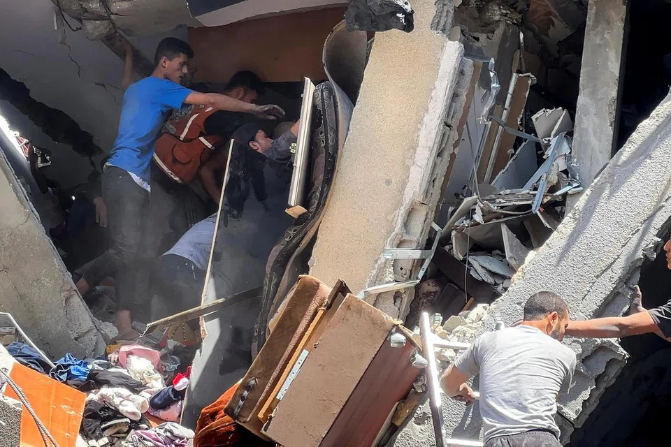 Penduduk Palestin memeriksa bangunan yang rosak akibat serangan udara Israel di kawasan Shejaia, Bandar Gaza, pada 10 April.