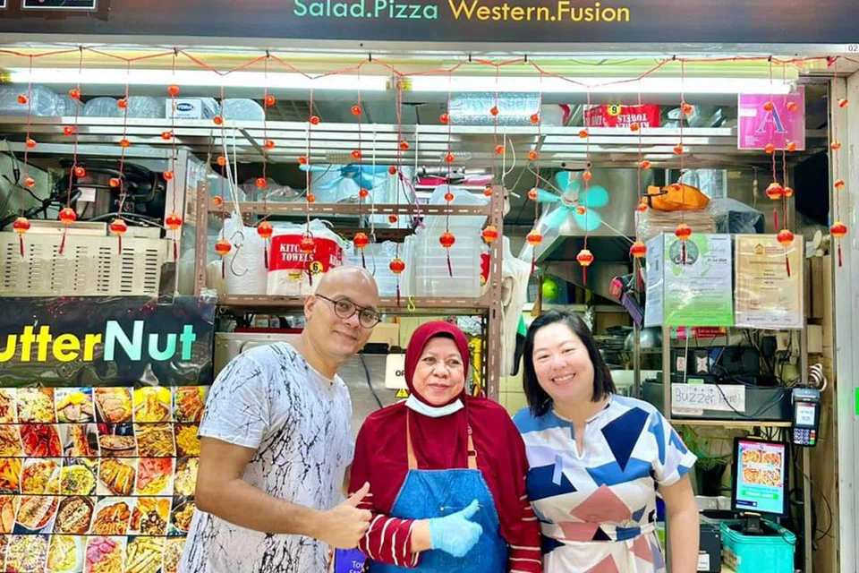 USAHA DIIKTIRAF: Kededua pengasas ButterNut, Cik Vivian Liem (kanan) dan suaminya, Encik Daren Lionel Oliveiro, merupakan pemenang Anugerah Penjaja Berdaya Usaha di Anugerah Penjaja Singapura 2023. Bersama mereka ialah Cik Siti Banun (tengah), pekerja paling lama di gerai tersebut.