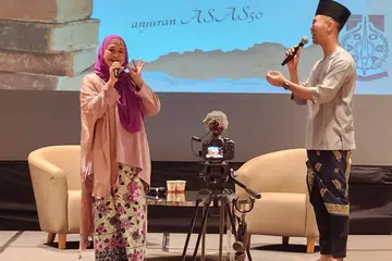 MENGHIBUR HADIRIN: Cikgu Khaziah Yem (kiri) berduet dengan Encik Afi Hanafi mendendangkan lagu ‘Gurindam Jiwa’. 