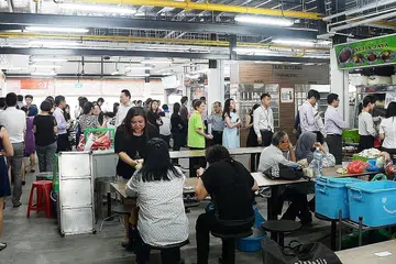 DIPENUHI PELANGGAN: Orang ramai beratur panjang di beberapa gerai, termasuk gerai Setia Jaya, di pusat sementara Pusat Makanan Market Street, yang berpindah dari Tempat Letak Kereta Golden Shoe ke Cross Street awal minggu ini. - Foto JOHARI RAHMAT