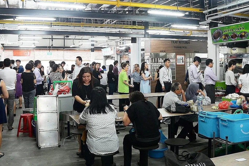 DIPENUHI PELANGGAN: Orang ramai beratur panjang di beberapa gerai, termasuk gerai Setia Jaya, di pusat sementara Pusat Makanan Market Street, yang berpindah dari Tempat Letak Kereta Golden Shoe ke Cross Street awal minggu ini. - Foto JOHARI RAHMAT