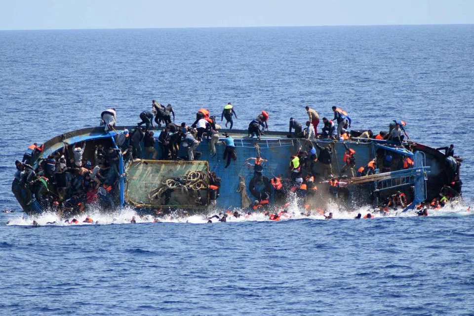 SAAT-SAAT MENDEBARKAN: Gambar petikan tentera laut Italy ini menunjukkan keadaan bot pelarian yang membawa muatan berlebihan menjongket sejurus melihat kehadiran sebuah bot rondaan sebelum tenggelam tidak jauh dari perairan Libya semalam. - Foto AFP