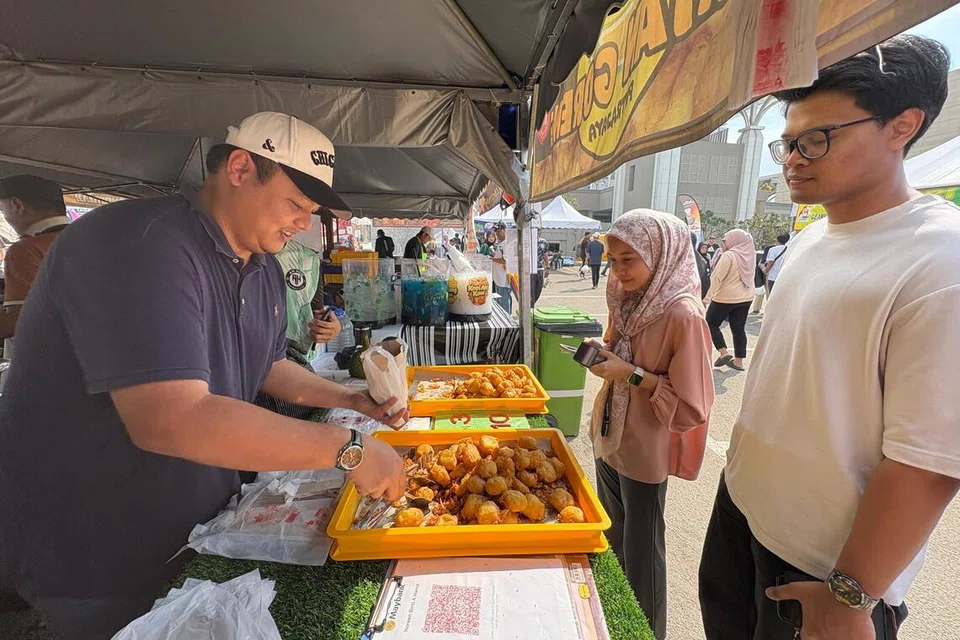 Durian goreng jualan Encik Abdul Rahman Idris (kiri), di bazar Ramadan Presint 3, Putrajaya, mendapat sambutan baik pelanggan. 