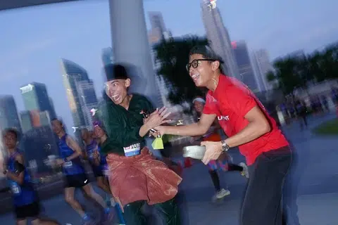 Meskipun tidak jelas, Encik Dani (kiri) dilihat berlari semasa acara separuh maraton itu dan ditemui rakannya di jalan raya.