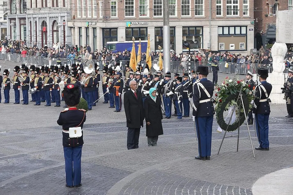 BERI PENGHORMATAN: Puan Halimah Yacob, yang ditemani suaminya Encik Mohamed, meletakkan lingkaran bunga di kaki Monumen Negara di Dam Square, Amsterdam, dan memberi penghormatan kepada askar dan orang awam yang terkorban semasa peperangan. - Foto MCI