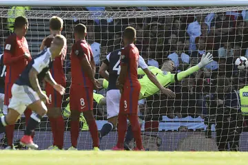 TERPEDAYA: Penjaga gawang England, Joe Hart, gagal menyelamatkan gawangnya daripada sepakan percuma pemain Scotland, Leigh Griffiths. - Foto AFP