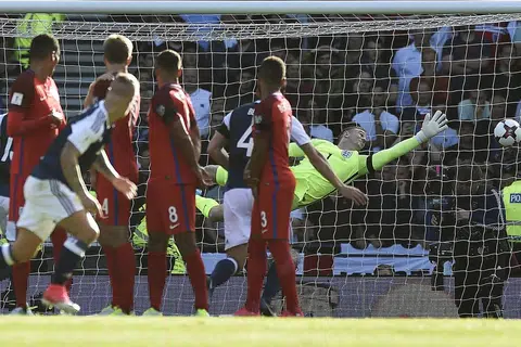 TERPEDAYA: Penjaga gawang England, Joe Hart, gagal menyelamatkan gawangnya daripada sepakan percuma pemain Scotland, Leigh Griffiths. - Foto AFP