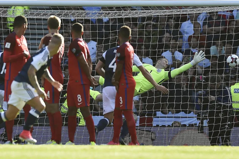 TERPEDAYA: Penjaga gawang England, Joe Hart, gagal menyelamatkan gawangnya daripada sepakan percuma pemain Scotland, Leigh Griffiths. - Foto AFP