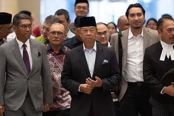 Mantan Perdana Menteri kelapan merangkap Pengerusi Perikatan Nasional, Tan Sri Muhyiddin Yassin (tengah) diiringi pemimpin Parti Pribumi Bersatu Malaysia (Bersatu) di Istana Kehakiman Putrajaya pada 11 September. 