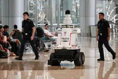 ‘MATA’ TAMBAHAN: Dua pegawai polis melakukan rondaan di  Terminal 4 Lapangan Terbang Changi dengan dibantu sebuah robot ronda polis yang berupaya memantau keadaan dan mengeluarkan isyarat operasi polis.