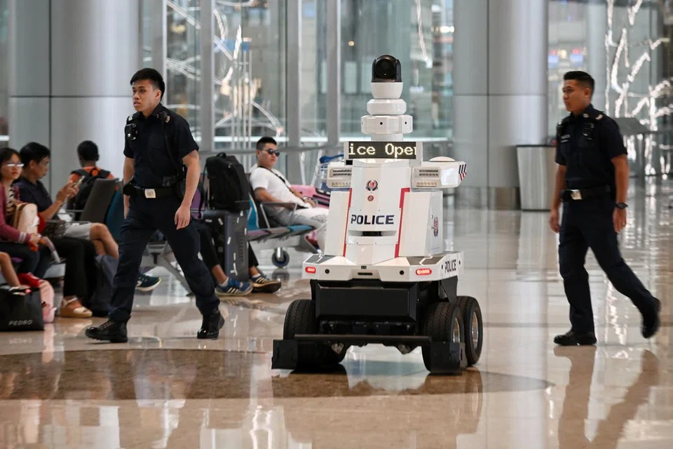 ‘MATA’ TAMBAHAN: Dua pegawai polis melakukan rondaan di  Terminal 4 Lapangan Terbang Changi dengan dibantu sebuah robot ronda polis yang berupaya memantau keadaan dan mengeluarkan isyarat operasi polis.