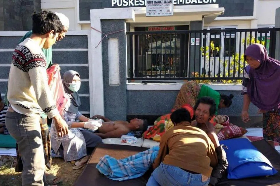 BERI BANTUAN: Paramedik membantu individu yang cedera di luar hospital selepas satu gempa bumi yang melanda Lombok pada 29 Julai 2018.