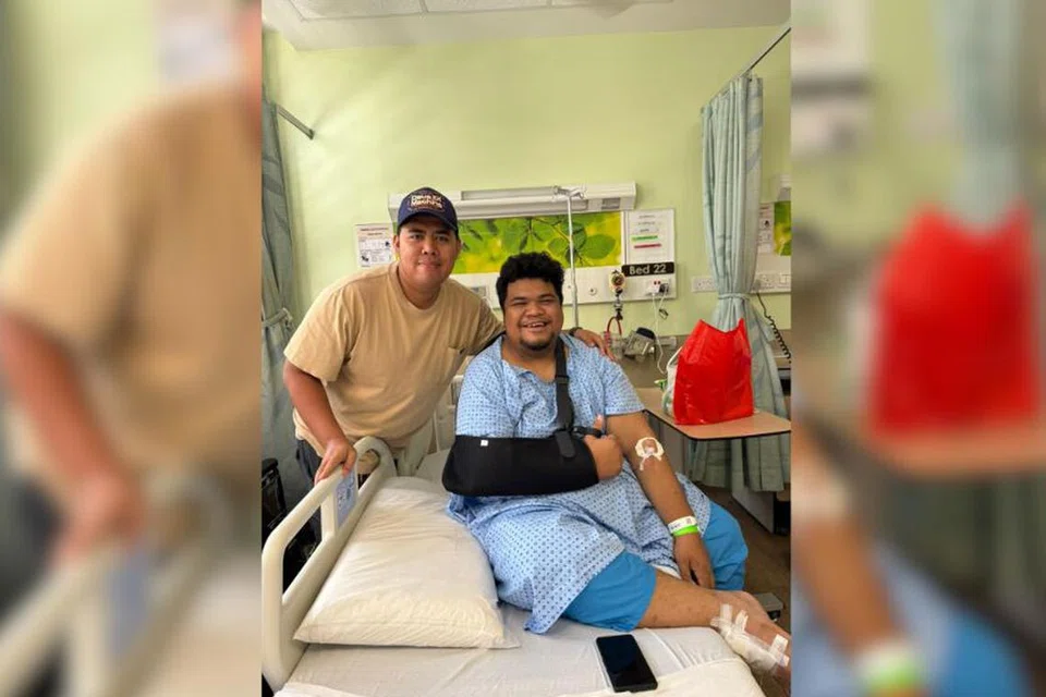 Encik Firdaus Hatta Mohammed, 33 tahun (baju biru) diziarah temannya Encik Hisyam Sulaiman, 34 tahun ketika sedang dirawat di Hospital Universiti Nasional Singapura (NUH).