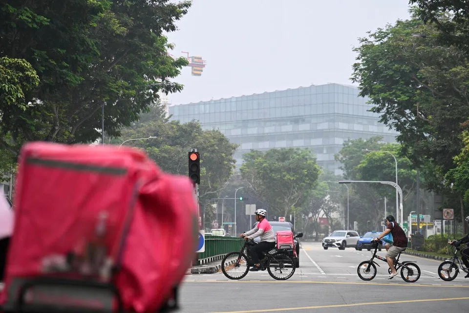 Encik Luqman (tengah), bertugas sebagai rakan penghantar sepenuh masa dari Mac 2025 hingga Oktober 2026. Beliau menggunakan basikal dan biasanya mengambil pesanan di daerah Tampines.