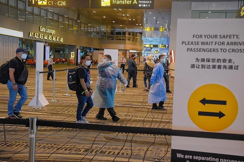DILARANG BERINTERAKSI: (Gambar atas) Kakitangan dikerah ke beberapa kawasan untuk mengawal pergerakan pelawat bagi memastikan penumpang yang tiba dan keluar dari lapangan terbang tidak berinteraksi antara satu sama lain. - Foto BH oleh MARK CHEONG 