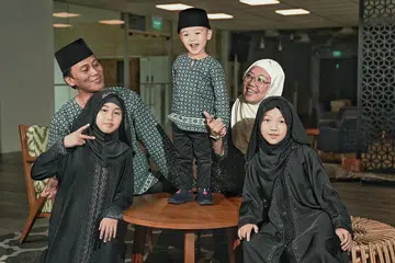 HIDUP KEMBALI NORMAL: Dilahirkan pada 29 Februari 2020, kehidupan awal Upu Jazli Eilhan Shah (diri atas meja) dipenuhi banyak sekatan pandemik Covid-19. Namun dengan Singapura kini dalam tahap Dorscon hijau, Eilhan dan keluarganya - ibu, Cik Nur Ri'an Abdullah Lim Ruiyan (tudung putih); bapa, Encik Upu Jallauddin Joosoph; dan dua kakaknya, Utin Nurqaseh Rina (depan, kiri) dan Utin Nurqistina Zara - kini dapat menikmati hidup secara bebas dalam keadaan normal. - Foto BH oleh KHALID BABA