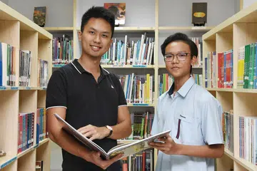 BELAJAR IKUT KEUPAYAAN: Rizq Irfan Nasharudyn, yang mengambil tiga subjek Pengumpulan Berdasarkan Subjek (SBB) semasa di menengah satu berkata teman dan gurunya seperti Encik Godwin Tan (kiri) banyak membantu dalam memantapkan lagi pemahamannya dalam subjek SBB yang diambilnya. - Foto BH oleh KHALID BABA