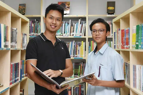 BELAJAR IKUT KEUPAYAAN: Rizq Irfan Nasharudyn, yang mengambil tiga subjek Pengumpulan Berdasarkan Subjek (SBB) semasa di menengah satu berkata teman dan gurunya seperti Encik Godwin Tan (kiri) banyak membantu dalam memantapkan lagi pemahamannya dalam subjek SBB yang diambilnya. - Foto BH oleh KHALID BABA