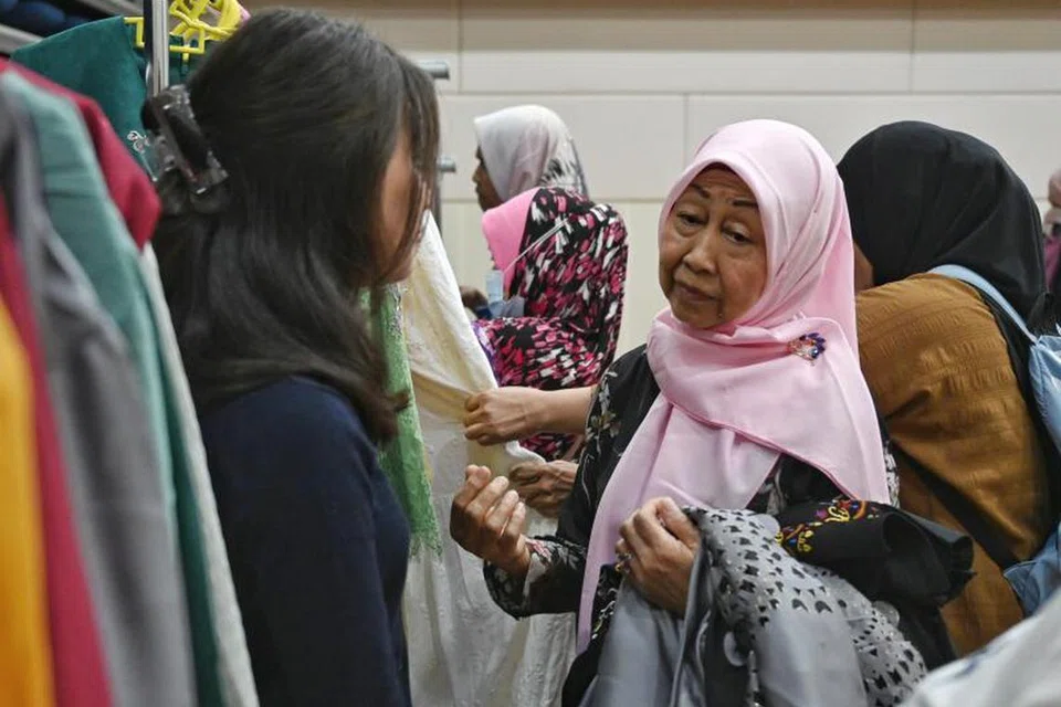 Cik Fatimah Ahmad (kanan) berbicara bersama sukarelawan di acara Projek Khas Untukmu yang menghadiahkan keluarga kurang berkemampuan dengan pakaian Hari Raya serba baru tajaan butik pakaian Raya di sini.