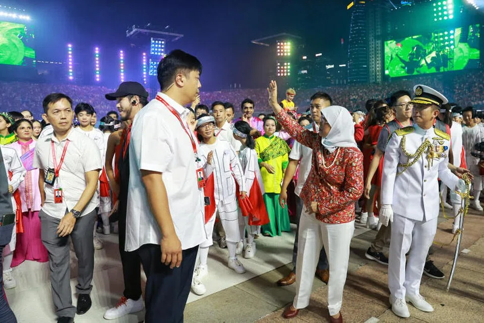 KALI TERAKHIR: Presiden Halimah Yacob melambai kepada peserta Perbarisan Hari Kebangsaan (NDP) sebelum beliau mengundur diri daripada Padang buat kali terakhir sebagai Presiden.
