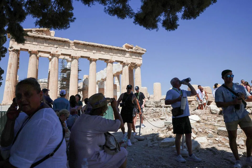 Orang ramai berdiri di kawasan teduh ketika melawat Acropolis pada permulaan gelombang haba selama tiga hari dengan suhu dijangka melebihi 40 darjah Celsius, di Athens, Greece, 7 Julai 2025.