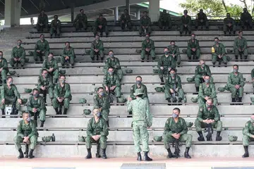 LANGKAH KESELEMATAN TAMBAHAN: Para rekrut yang menjalani latihan ketenteraan di BMTC memerhatikan langkah keselamatan kesihatan tambahan seperti memakai pelitup dan menjaga jarak selamat antara satu sama lain. - Foto BH oleh TIMOTHY DAVID
