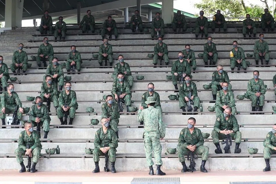 LANGKAH KESELEMATAN TAMBAHAN: Para rekrut yang menjalani latihan ketenteraan di BMTC memerhatikan langkah keselamatan kesihatan tambahan seperti memakai pelitup dan menjaga jarak selamat antara satu sama lain. - Foto BH oleh TIMOTHY DAVID