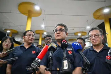 Setiausaha Agung Titik Merah Bersatu (RDU), Encik Ravi Philemon (tengah), bercakap kepada media sebelum melakukan lawatan di Pusat Makanan Yishun Park pada 3 April.