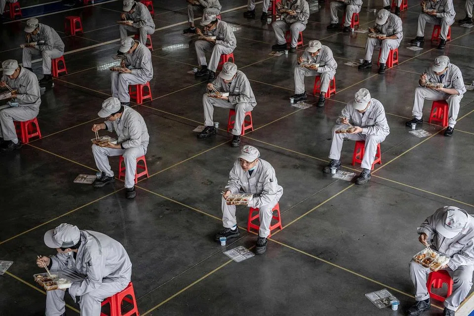 RAKAMAN GETIR: Gambar ini dirakamkan pada 23 Mac tahun ini menunjukkan pekerja makan tengah hari di loji pembuatan auto Dongfeng Honda di Wuhan, wilayah Hubei, China. - Foto AFP 