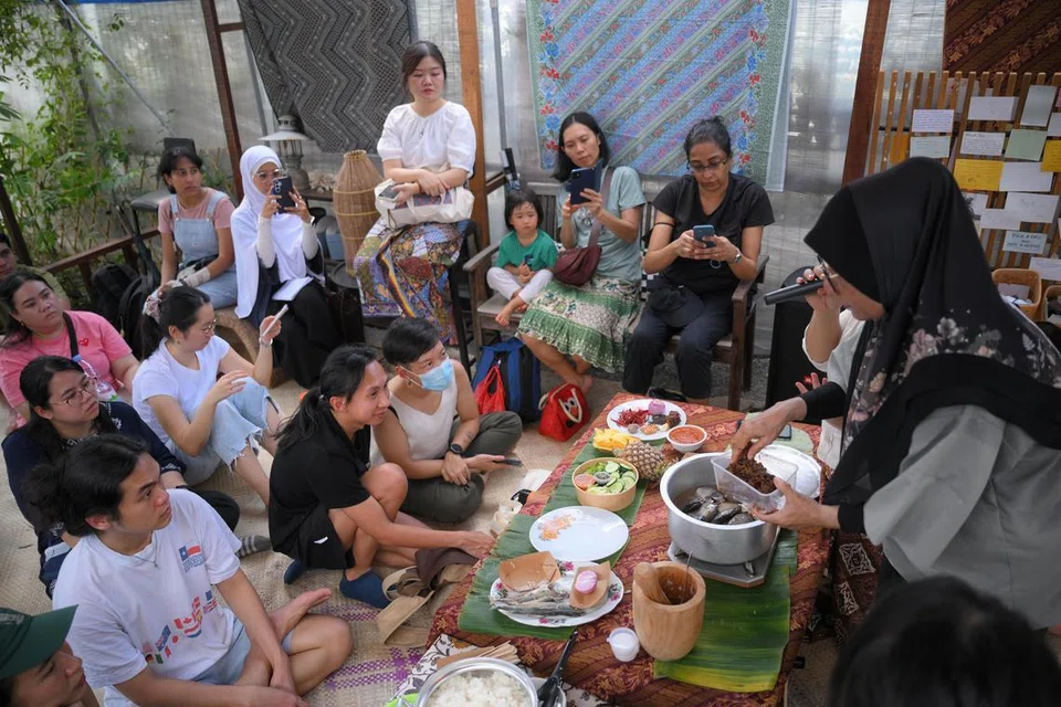 Cik Rohani Rani (kanan), mengajar masakan orang Semakau semasa bengkel Hari Orang Pulau pada 14 Jun. 