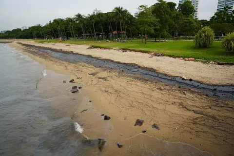 Pasir di pantai East Coast Park kelihatan hitam diselaputi minyak pada 16 Jun.