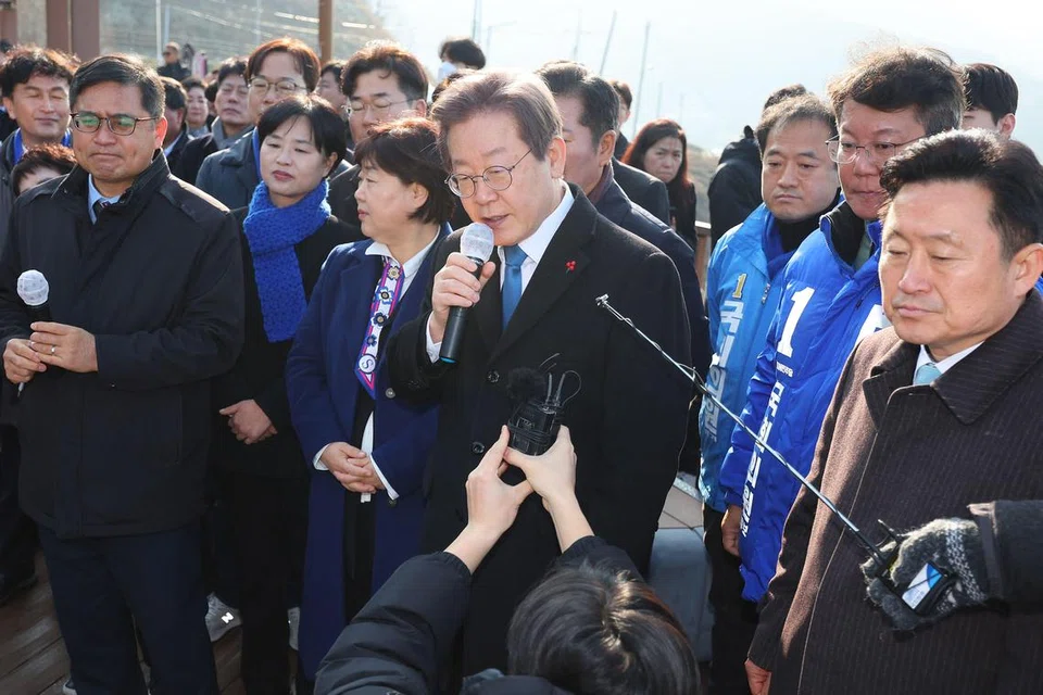 SEBELUM DITIKAM: Ketua parti pembangkang Korea Selatan Encik Lee Jae-myung (memegang mikrofon) semasa bercakap kepada wartawan sebelum ditikam di leher pada 2 Januari oleh seorang lelaki yang berpura-pura menjadi penyokongnya. 