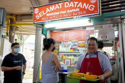 GERAI ASAL: Encik Sumadi Sapari, 55 tahun, kelihatan bergambar di depan gerai asal Selamat Datang Warong Pak Sapari di Pusat Makanan Adam Road yang ditutup buat sementara ini bagi kerja naik taraf.