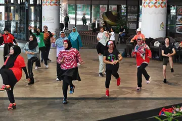 Cik Noraishah Mostapa (dua dari kiri, barisan depan) dan Cik Angela Tan (lima dari kiri) adalah antara 40 peserta yang melibatkan diri dalam Gerak Budaya Zumba yang diadakan demi mempromosikan gaya hidup sihat dan memeriahkan Jalur Budaya Geylang Serai. 