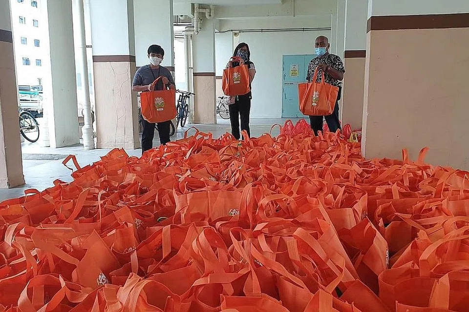PENUHI JANGKAAN PENDUDUK: Encik Fahmi (tengah), yang menyertai pengagihan bubur dan barangan dapur kepada penduduk minggu lalu, berkata ramai penduduk yang ditemuinya telah bertanya tentang program-program yang bakal dianjurkan bagi mereka. - Foto PERSATUAN RAKYAT