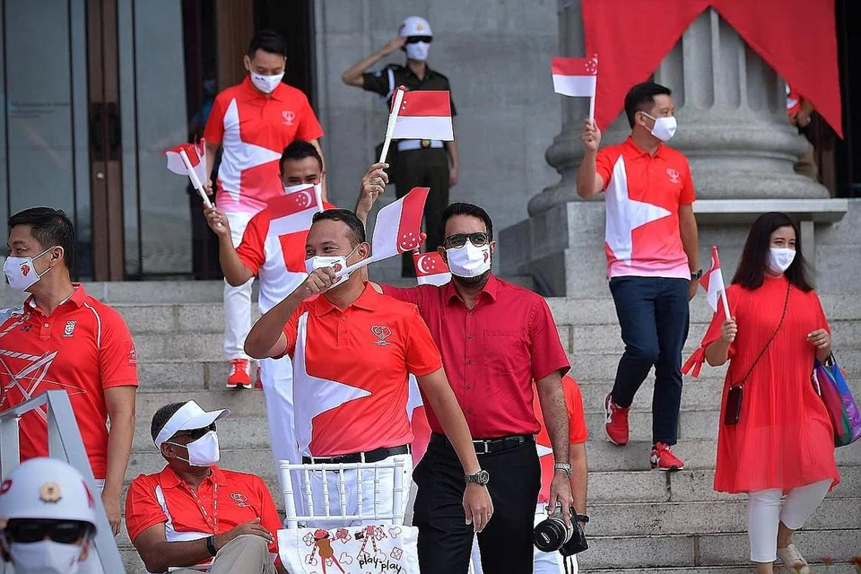 RAIKAN BERSAMA: (Dari kiri) Mayor Majlis Pembangunan Masyarakat (CDC) South East Fahmi Aliman dan Ketua Pembangkang Pritam Singh (tengah) antara Anggota Parlimen yang dilihat hadir di Perbarisan Hari Kebangsaan di Padang pagi semalam. 