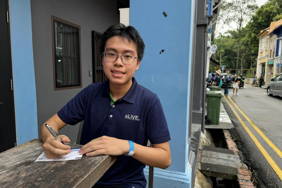 Adam Mustaqim Mohammed Adlil menulis kata-kata positif di kertas untuk menyebarkan keceriaan kepada orang ramai dalam satu kegiatan sewaktu Jejak Warisan Wakaf pada 24 Ogos.