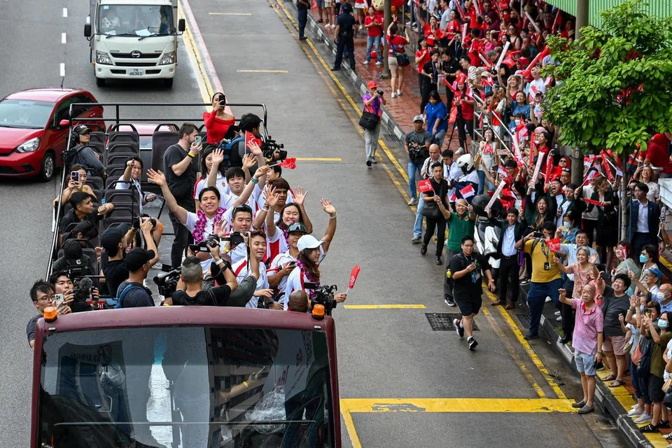 Pemenang pingat gangsa dalam acara luncur lelayang, Maximilian Maeder, bersama rakan-rakan Olimpiknya yang lain melambai kepada penyokong di Eu Tong Sen Street pada 14 Ogos. Terletak di kawasan Chinatown, ia juga merupakan titik sorakan kedua dalam perjalanan bas itu. 