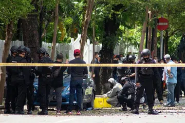 SIASATAN DIJALANKAN: Beberapa pegawai polis forensik sedang meninjau situasi yang melanda di hadapan gereja Katolik di Makassar, Sulawesi Selatan, menyusuli pengeboman yang berlaku pada Ahad (28 Mac). - Foto EFA-EPA