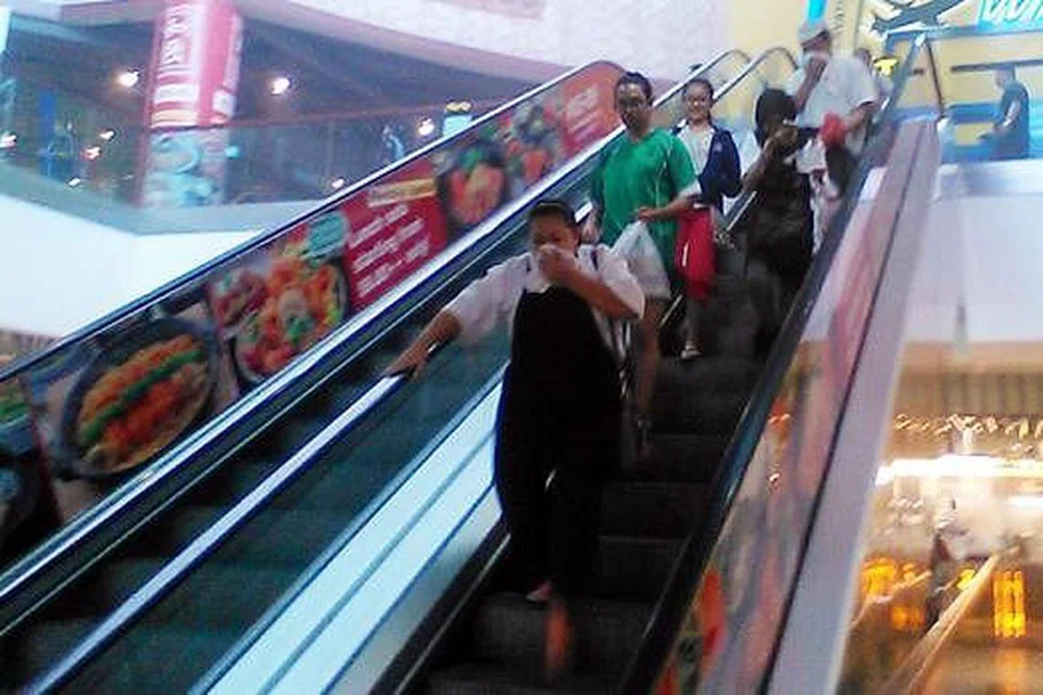 LARI DARIPADA ASAP: Beberapa orang bergegas turun menggunakan tangga bergerak meninggalkan medan selera Bagus di Causeway Point apabila salah sebuah gerai makan di situ terbakar. - Foto A. RAHMAN BASRUN