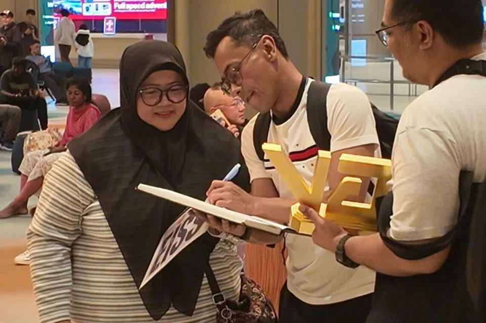 Peminat tegar, Cik Siti Salimah Saimbran (kiri), sanggup datang dari Woodlands untuk menyambut idolanya, pemenang juara ‘Gegar Vaganza 12’, Iskandar Ismail, di Lapangan Terbang Changi.