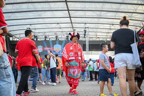 ‘SAMPING BOY’: Encik Mohammad Muhaimin berjalan dengan bangga di sekitar ‘fanzone’ dengan pakaian lengkapnya yang terdiri daripada bendera Liverpool yang terikat di pinggangnya bak samping. Terdapat juga bendera dengan reka bentuk sayap di belakangnya, skarf, sepatu serta topi ‘joker’ pasukan Liverpool. Inilah kostum yang digunakannya di semua perlawanan Liverpool di Singapura ataupun luar negara.