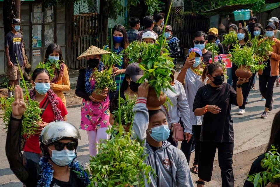 PERSATUAN RAKYAT: Rakyat Myanmar di Mandalay mengetepikan dwi perayaan, pesta air Songkran dan sambutan tahun baharu Thingyan, sejak 13 April lalu sehingga semalam dan berarak secara aman dengan menunjukkan tiga jari sambil membawa pasu dipenuhi bunga A-taui bagi menunjukkan sokongan terhadap bantahan ke atas rejim tentera yang merampas kuasa daripada pemerintah demokratik pimpinan Cik Aung San Suu Kyi pada 1 Februari lalu. - Foto AFP