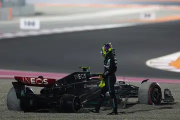 AKSI BAHAYA: Pemandu Mercedes, Lewis Hamilton, berdiri di sebelah keretanya selepas satu kemalangan di Grand Prix Qatar. Beliau kemudian melintas trek walaupun perlumbaan masih berlangsung, menyebabkan beliau didenda.