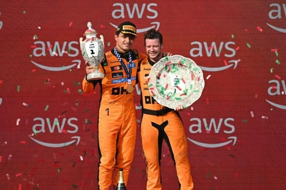 Pemandu McLaren dari Britain, Lando Norris (kiri), bersama seorang anggota pasukannya meraikan kemenangan sambil memegang trofi di podium selepas Grand Prix (GP) Formula Satu (F1) Hungary di Litar Hungaroring, Mogyoród, berhampiran Budapest, Hungary, pada 26 Julai 2026. Norris menewaskan rakan sepasukannya, Oscar Piastri, selepas McLaren melaksanakan strategi pit yang tepat.
