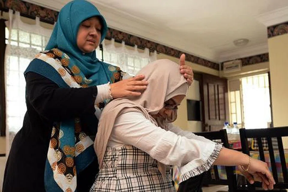 SENTUHAN RINGAN: Cik Fauziah mengurut perlahan kepala ibu hamil, Cik Hasina Mustakim, dengan menggunakan hujung jarinya sahaja. Ini bertujuan mengurangkan tekanan sekali gus menggalakkan kesihatan emosi si ibu secara keseluruhan.