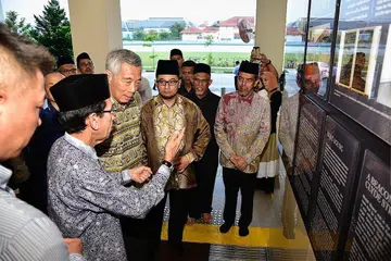 SEJARAH MASJID: Presiden Muis, Haji Mohd Alami Musa (kiri) memberi taklimat kepada Encik Lee (dua dari kiri) mengenai sejarah Masjid Maarof. Bersama mereka ialah (bermula tiga dari kiri) Ustaz Rashid, Encik Masagos dan Haji Abdul Razak. - Foto-foto BH oleh DESMOND WEE