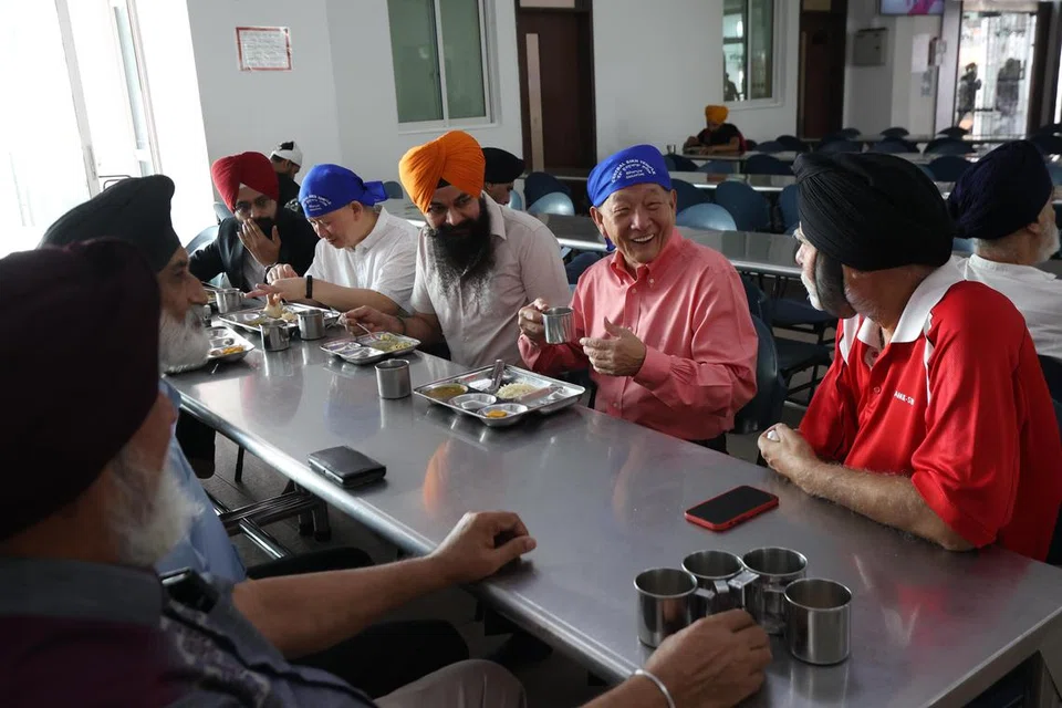 BERAMAH MESRA: Bakal calon presiden, Encik Ng Kok Song (dua dari kanan), bersarapan dengan wakil kuil Sikh semasa lawatannya ke Kuil Pusat Sikh di Towner Road pada Ahad. 