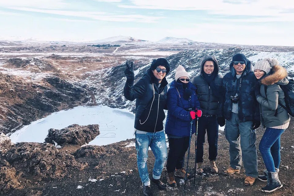MELANCONG SAMBIL TINGKATKAN KEMESRAAN: Penulis (dua dari kanan) bersama keluarga mendaki gunung untuk melihat sendiri kawah gunung berapi berisi air yang telah beku di Iceland. - Foto SAINI SALLEH 