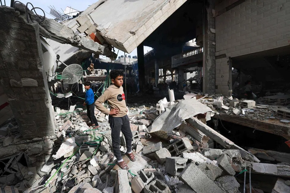 Penduduk Palestin melihat dari dekat bangunan-bangunan yang musnah akibat serangan Israel di Rafah, selatan Gaza.